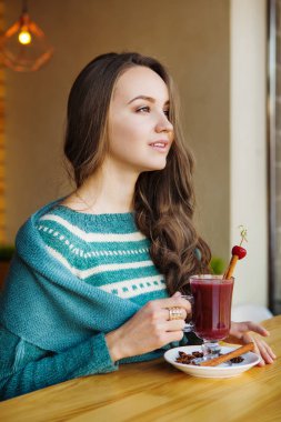 Kafede oturan ve zevk onun güler yüzlü kadın
