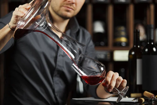 Sommelier häller vin i glas från att blanda skål. Manlig servitör — Stockfoto