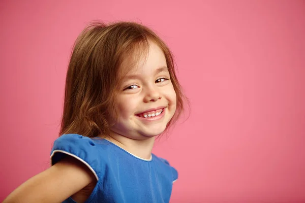 Dziewczynka z uroczym uśmiechem na białym tle na różowym tle. — Zdjęcie stockowe
