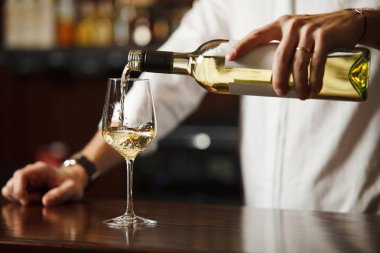 Sommelier bardaklara alkol dolduruyor.
