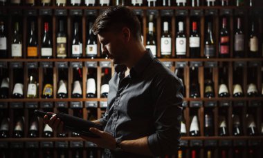 Sommelier eller karanlıkta büyük şarap şişesi holding