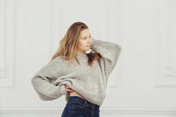 Профиль женщин в бесформенном свитере, стоящих у стены — стоковое фото