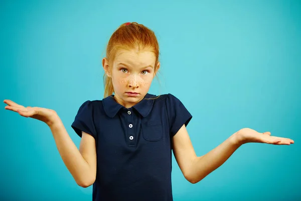 Potret gadis berusia tujuh tahun mengangkat bahu dan merentangkan tangannya mengungkapkan ketidaktahuan atau kebingungan ini . — Stok Foto