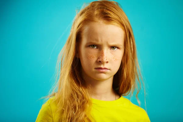 Enfants en colère fille aux cheveux roux isolé sur bleu . — Photo