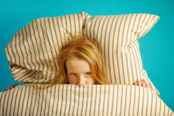 Menina Childr deitado na cama e espreitando debaixo do cobertor, vista superior . — Fotografia de Stock