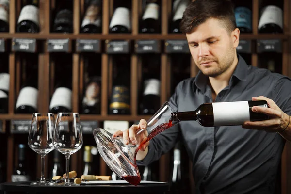 Серйозний сомельє, що поливає червоне вино в декантер — стокове фото