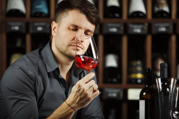 Сомельє дивиться на червоне винне скло з напоєм — стокове фото