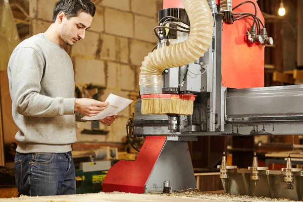 De mens stelt het programma in op de CNC machine. Apparaat met numerieke besturing. — Stockfoto