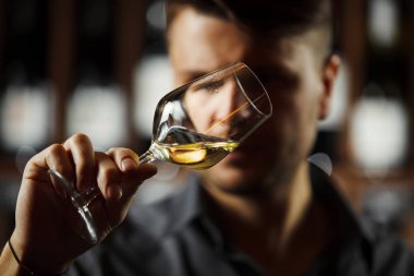 Arka planda bir şişe beyaz şarap, erkek şarap garsonu içkinin değerini biliyor.