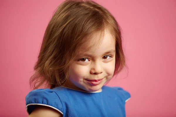 stock image Shy little girl with cute look, close-up portrait on pink isolated background.