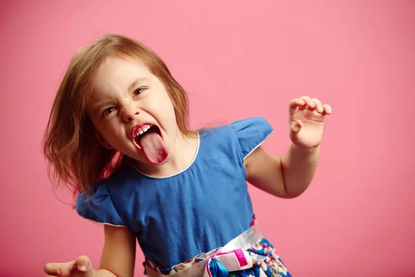 Enojada niña muestra su lengua en divertida mueca — Foto de Stock