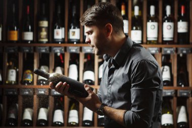 Sommelier şarap şişesi holding ile toz kaplı