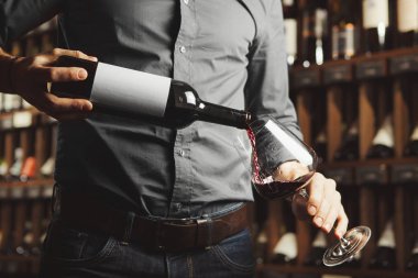 Erkek Sommelier kırmızı şarap vinç içine döküm yakın fotoğraf. Alkol İçecek şişe ile garson.