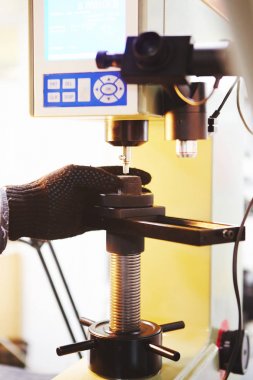 Laboratuvarda evrensel sertlik testleyicisinin dikey yakın çekim.