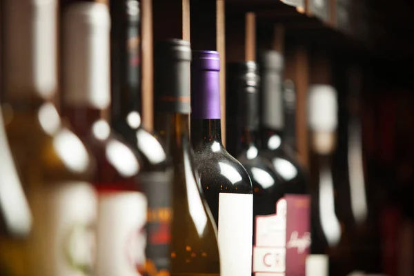 Şarap mahzeninde seçkin içecekler yazılı isimlerle raflarda.
