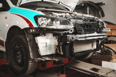 Onarım sırasında garajda sökülen beyaz arabanın yakın çekim. Kaza dan sonra aracın kurtarılması.