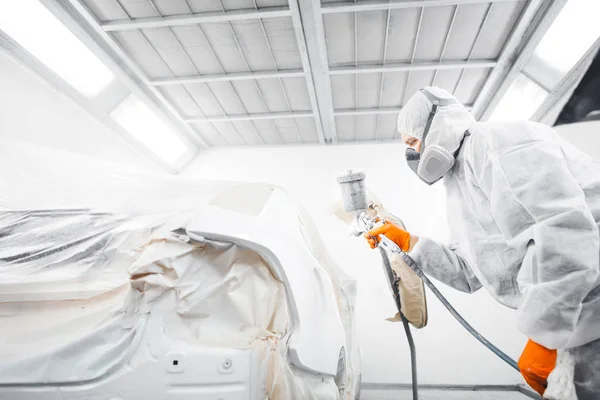흰색 페인트 부스에서 자동차에 페인트를칠 하는 남자 근로자. — 스톡 사진