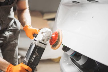 Arabayı boyadıktan sonra vernik parlatma, yakın çekim. Otomatik gövde için taşlama makinesi.