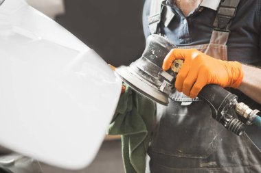 Oto tamircisi boyamadan önce beyaz arabayı parça parça öğütüyor, yakın plan..