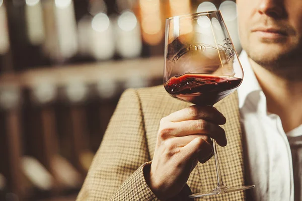 Bokal de vino tinto en el fondo, sommelier masculino apreciar bebida — Foto de Stock