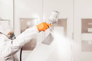 Yakın çekim, boya odasında tamirci boyama araba gövde elemanları el.