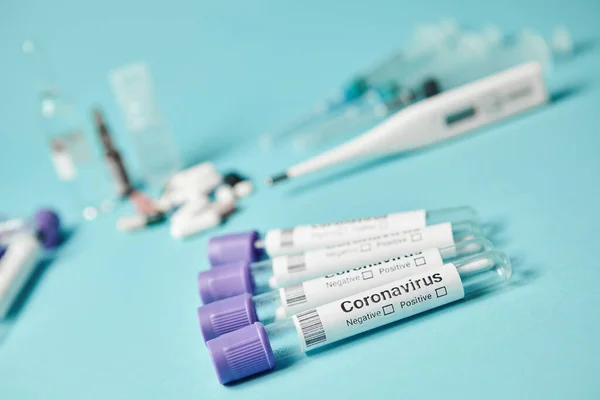 Tubos de ensaio médicos com um teste de coronavírus em fundo azul. Testes para determinar o vírus covid-19 . — Fotografia de Stock