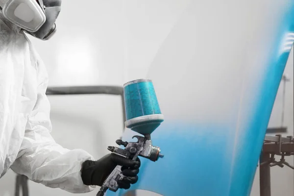 Homem pulveriza corante azul sobre os elementos do veículo. — Fotografia de Stock