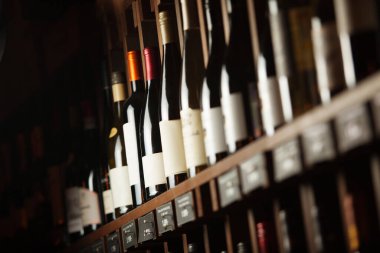 Şarap mahzeninde seçkin içecekler yazılı isimlerle raflarda.