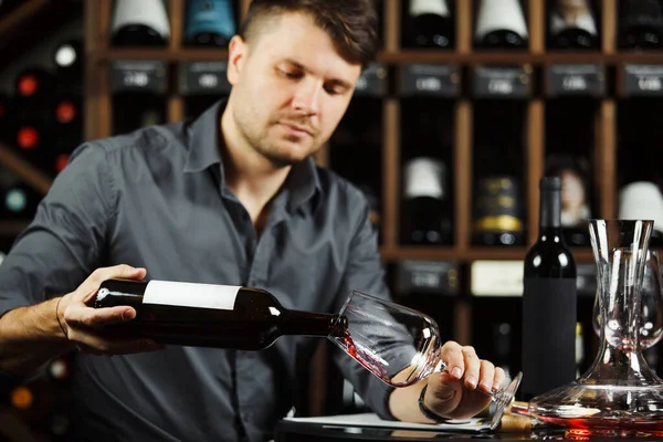 Сомельє наливає червоне вино з пляшки в склянку — стокове фото
