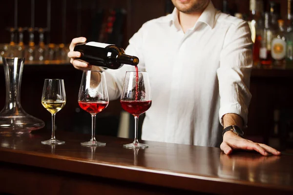 Sommelier pouring different types of fine wine