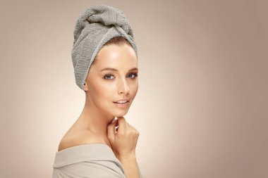 Güzel beyaz kadın model bornoz ve havluyla izole edilmiş bej arka plan, güzellik çekimi.