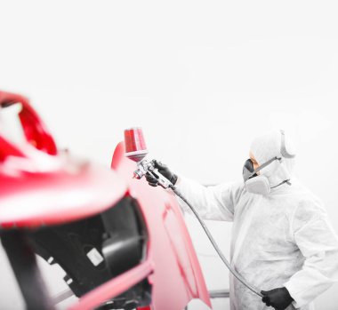 Adam aracın elementlerine kırmızı boya püskürtür. Boş kopyalama alanı.