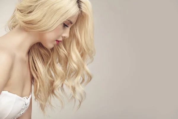 Perfil retrato de mulher loira com um cabelo encaracolado no fundo bege — Fotografia de Stock