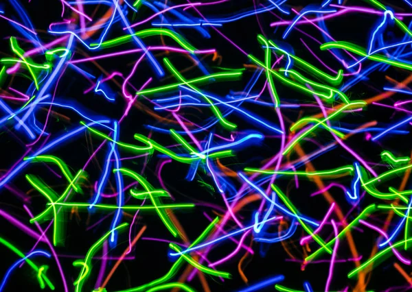 Karanlık bir arka plan üzerinde renkli soyut eğri çizgiler.