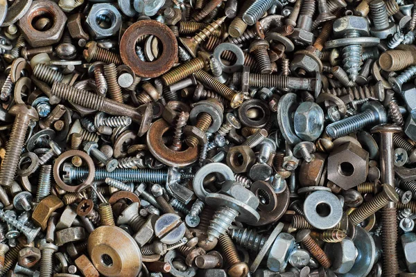 Çeşitli vidalar, somunlar, cıvatalar ve yıkıtaçılar ve diğer bağlantı elemanları ile soyut arka plan. Makro.