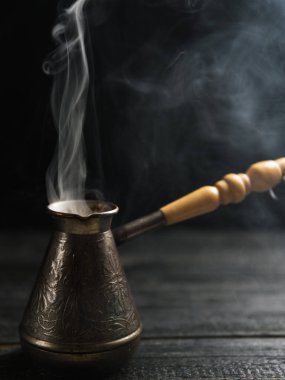 Sıcak buharlı kahve demliği. Ahşap arka planda taze demlenmiş kahve.