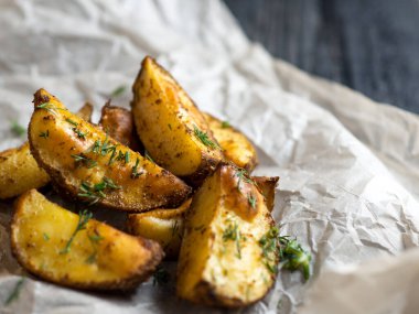 Ahşap bir masada dereotlu kızarmış patates.