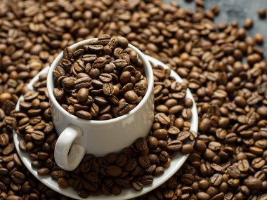 En kaliteli kahve çekirdekleri ile dolu beyaz kahve fincanı.