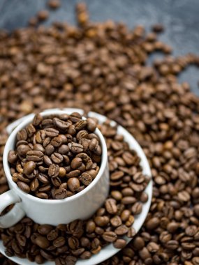 En kaliteli kahve çekirdekleri ile dolu beyaz kahve fincanı.