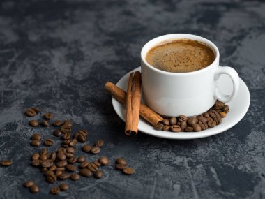 Telif uzayı beton masasında tarçınlı beyaz kahve fincanı.