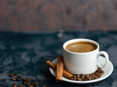 Telif uzayı beton masasında tarçınlı beyaz kahve fincanı.