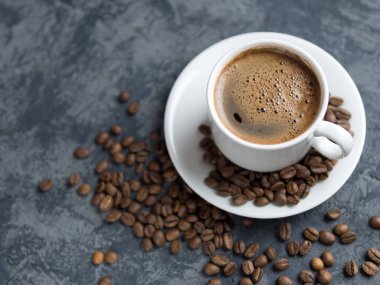 Telif uzayı beton masasında tarçınlı beyaz kahve fincanı.