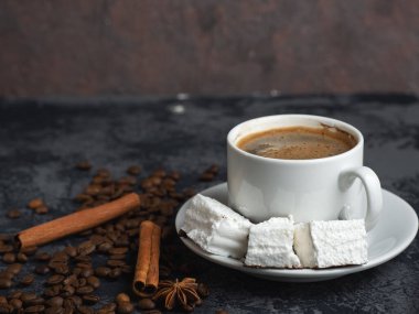 Beyaz kahve fincanı, siyah masada beyaz şekerleme ve kopyasal alan.