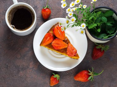 Masada bir fincan espresso ve çilekli turta.