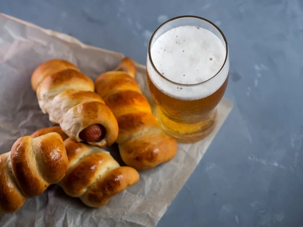 A glass of beer top view and homemade sausages in the dough. Beer and snacks