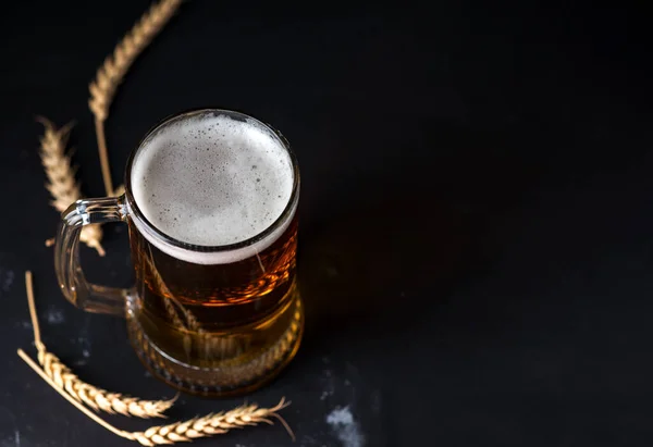 暗いテーブルの上にガラス製のビールマグカップ — ストック写真