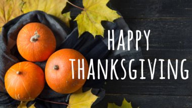 Balkabaklı ve siyah ahşap masa arkaplanlı Şükran Günü mesajınız kutlu olsun. Üst görünüm