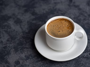 Telif alanı ile koyu arkaplan üzerine beyaz espresso kupası