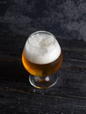 Puslu bir bardak Pilsner birasının yakın çekimi.