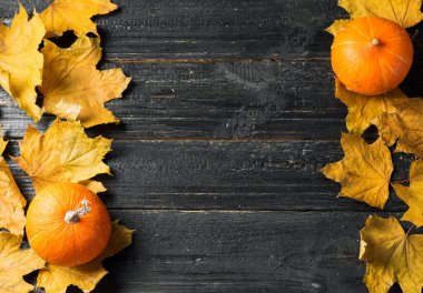 Eski ahşap zemin üzerinde sonbahar yaprakları ve balkabağı kopyalama alanı ile